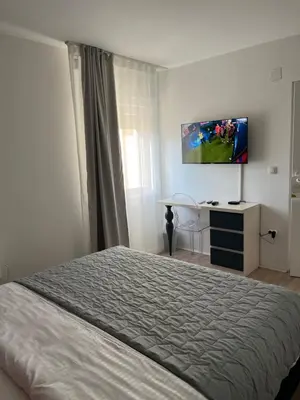 a bedroom with a bed and a tv on the wall at Race for Space in Niš