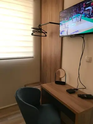 a room with a desk with a television and a chair at Race for Space in Niš