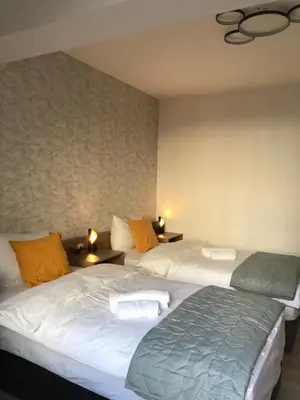 two beds in a room with two lamps on tables at Race for Space in Niš