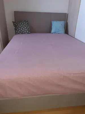 a bed in a small room with a pink bedspread at Aleksandar in Pirot