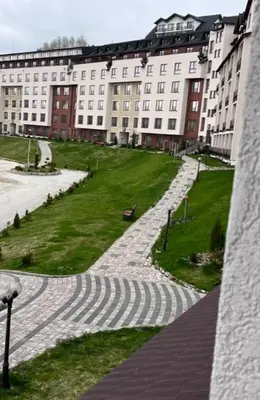 a view of a building with a grassy field and buildings at Majapartman in Kopaonik