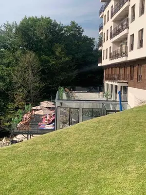 a building and a grassy hill next to a building at Majapartman in Kopaonik