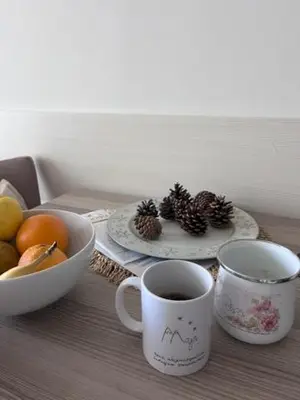 a table with two cups of coffee and a bowl of fruit at Majapartman in Kopaonik