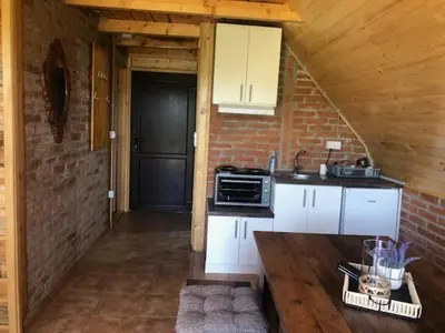 a kitchen with white cabinets and a counter top at Koliba Joca in Lepterija