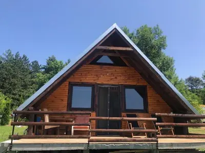 a small log cabin with a thatched roof at Koliba Joca in Lepterija