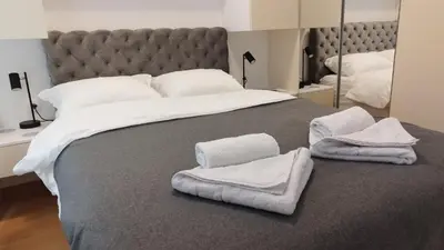 a bedroom with a large bed with towels on it at Royal Vila Bozovic - G5 i G6 in Vrnjačka Banja