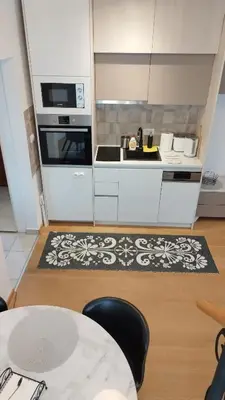 a kitchen with a table and a stove top oven at Royal Vila Bozovic - G5 i G6 in Vrnjačka Banja