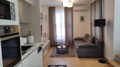 a small living room with a couch and a chair at Royal Vila Bozovic - G5 i G6 in Vrnjačka Banja