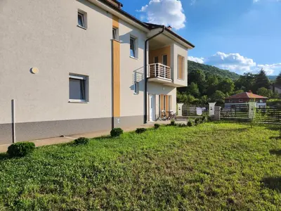 a house with a grass yard in front of it at Vila Kruna in Soko Banja