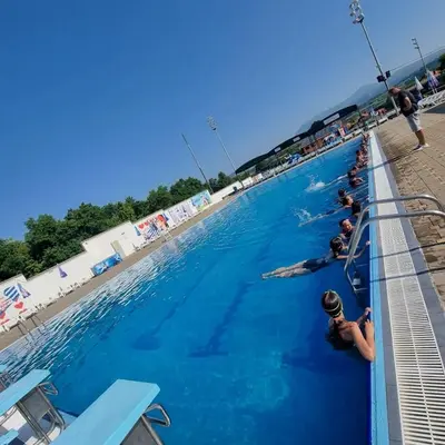 a group of people swimming in a swimming pool at Apartman Pan in Soko Banja