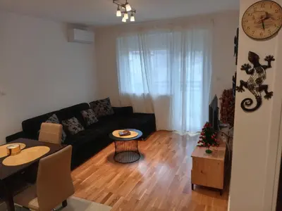 a living room with a black couch and a table at Apartman Pan in Soko Banja