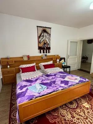 a bedroom with a large bed with a purple comforter at Idila pod Rtnjem - Najam cele vikendice sa bazenom in Ilino