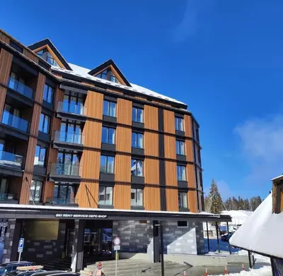 a large building with brown at Woodside Apartment in Kopaonik