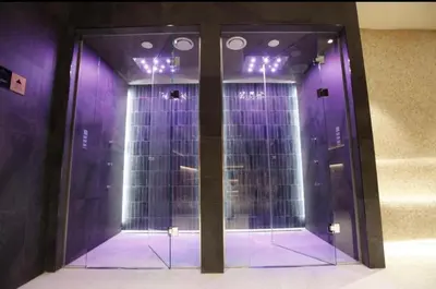 a room with purple walls and a glass door at Woodside Apartment in Kopaonik