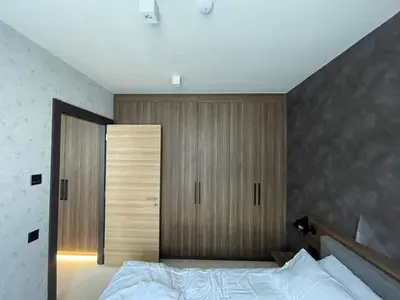 a bedroom with a bed and a wooden closet at Woodside Apartment in Kopaonik
