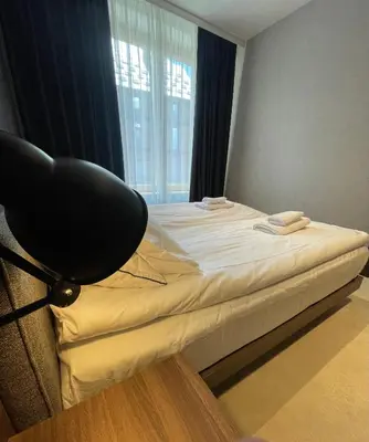 a bedroom with a bed with a chair and a window at Woodside Apartment in Kopaonik