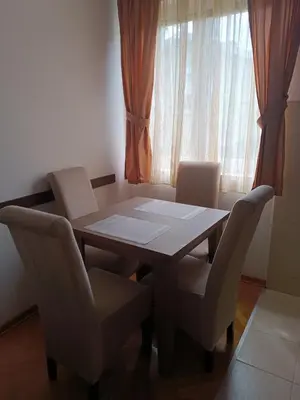 a table and chairs in a room with a window at DREAMER apartment in Vrnjačka Banja