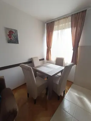 a dining room with a table and chairs and a window at DREAMER apartment in Vrnjačka Banja