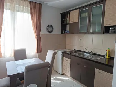 a kitchen with a table and a sink and a table and chairs at DREAMER apartment in Vrnjačka Banja