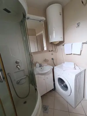 a bathroom with a washing machine and a sink at DREAMER apartment in Vrnjačka Banja
