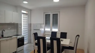a kitchen with a table and chairs in a room at Black and White in Pirot