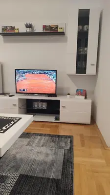 a living room with a flat screen tv on a wall at Black and White in Pirot