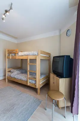 a room with two bunk beds and a television at Hostel Day 'N' Night in Niš
