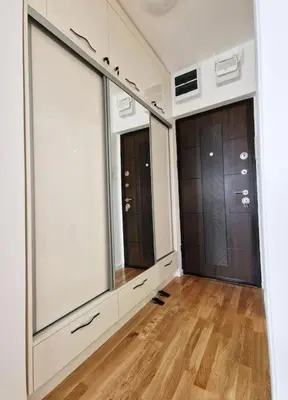 a room with three large windows and a wooden floor at Sunflower apartment in Niš