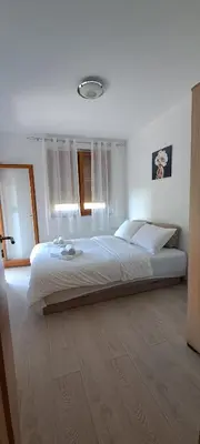 a bedroom with a large white bed in a room at Apartmani Talija 3 i 4 Sokobanja in Soko Banja