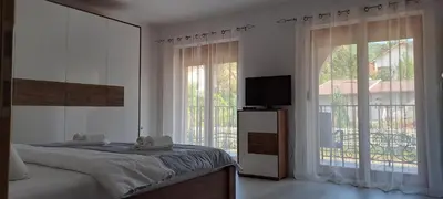 a bedroom with a bed and a large window at Apartmani Talija 3 i 4 Sokobanja in Soko Banja