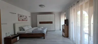a bedroom with a bed and a large window at Apartmani Talija 3 i 4 Sokobanja in Soko Banja