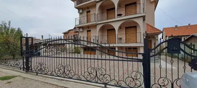 a black wrought iron fence in front of a building at Apartmani Talija 3 i 4 Sokobanja in Soko Banja
