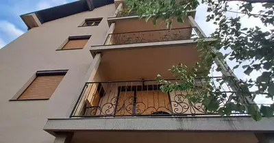a tall building with a balcony with a fence at Apartmani Talija 3 i 4 Sokobanja in Soko Banja