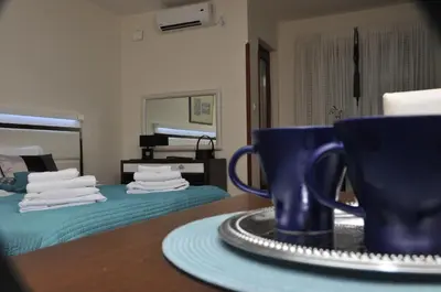a table with two blue cups and a plate on it at Apartments Biser in Vrnjačka Banja
