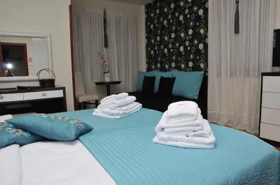 a blue bed with towels stacked on top of it at Apartments Biser in Vrnjačka Banja