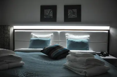 a bedroom with a bed with blue and white pillows at Apartments Biser in Vrnjačka Banja