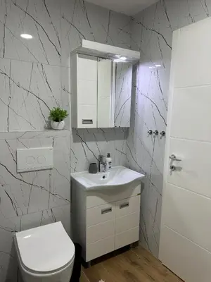 a bathroom with a toilet and a sink and a mirror at MM LUX apartment in Niš