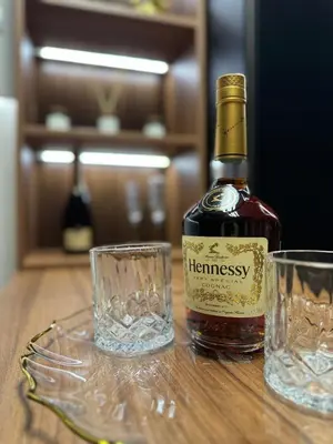 a bottle of whiskey next to two glasses on a table at MM LUX apartment in Niš