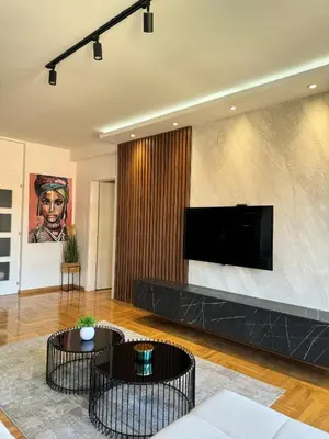 a living room with two tables and a flat screen tv at MM LUX apartment in Niš