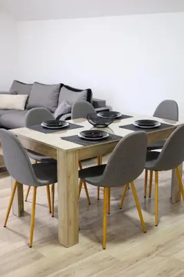 a dining room table with chairs and a couch at Studio Petra in Soko Banja