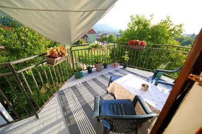 a balcony with chairs and a table and flowers at Studio Petra in Soko Banja