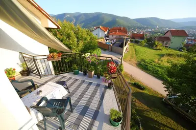 an outdoor patio with a table and chairs and flowers at Studio Petra in Soko Banja