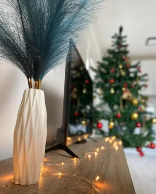 a wooden table with a christmas tree and a vase at Apartman Nikolic in Jagodina