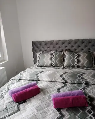 a bed with two purple pillows on it at Apartman Nikolic in Jagodina