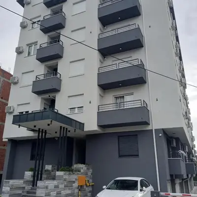 a white car parked in front of a building at Apartman Nikolic in Jagodina