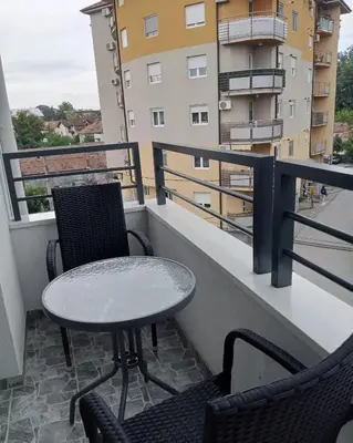 a table and two chairs on a balcony with a building at Apartman Nikolic in Jagodina