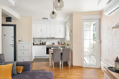 a kitchen and living room with a table and chairs at Duma Apartmani 1 Vrnjačka Banja in Vrnjačka Banja