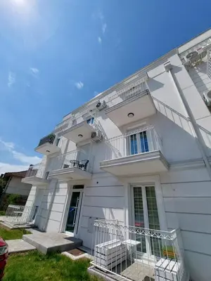 a white building with stairs and balconies on it at Duma Apartmani 1 Vrnjačka Banja in Vrnjačka Banja