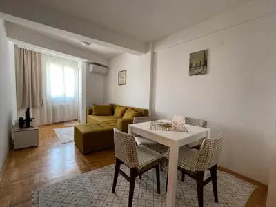 a living room with a table and chairs and a couch at Sedmi Juli in Niš