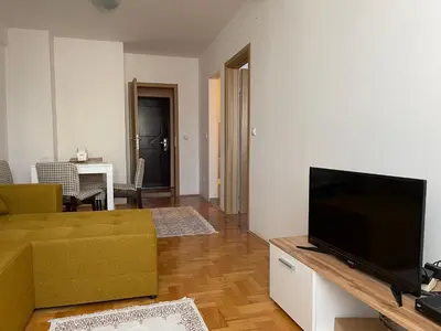a living room with a couch and a flat screen tv at Sedmi Juli in Niš